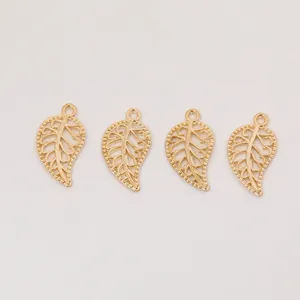 Détail de quatre pendentifs feuilles dorés en alliage avec nervures délicates