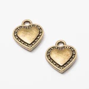 Dettaglio di ciondoli a cuore in bronzo con bordo puntinato per creazione gioielli fai-da-te