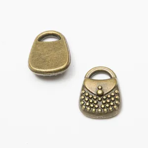 Close-up of vintage bronze alloy handbag charms with detailed beaded texture for DIY