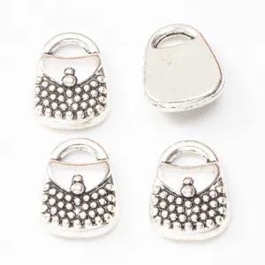 Macro detail of antique silver handbag pendants with beaded texture for DIY jewelry making