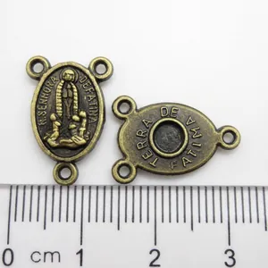 Detail showing religious Fatima metal charm connector for rosary with measurement scale