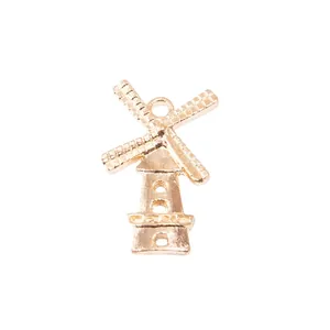 Polished gold metal windmill charm pendant with textured blades and circular hanging loop