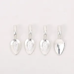 Close-up of four silver teardrop alloy pendant bases with textured diamond patterns