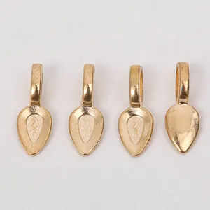 Close-up of four teardrop-shaped gold alloy jewelry bails with polished metallic finish