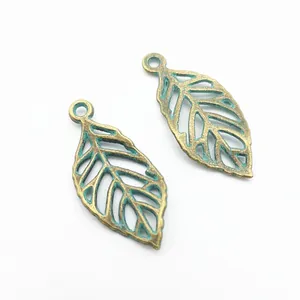 Détail de deux pendentifs feuilles creuses en bronze vintage pour bijoux DIY