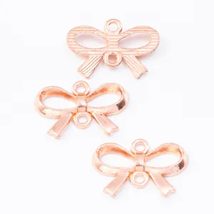 Macro view of rose gold zinc alloy bow pendants with double hanging loops for DIY jewelry