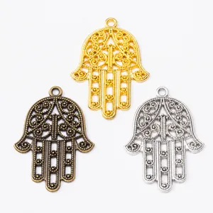 Detailed macro shot of vintage Hamsa Hand pendants in gold silver and bronze metal finishes