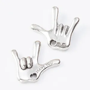 Macro detail of alloy hand gesture charms with I LOVE YOU engraving and heart cutouts
