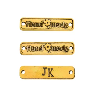 Makroaufnahme rechteckiger antiker Goldlegierungsetiketten mit Hand Made Gravur