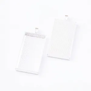 Detailed macro view of two silver alloy rectangular bezel trays with grid texture for DIY