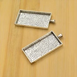 Detail of silver rectangular bezel trays with textured base for DIY jewelry making