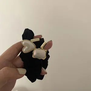 Detail of black pleated scrunchie with handmade heart and rectangle shell pendants