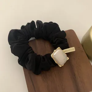 Elegante coletero negro con etiqueta dorada Handmade y detalle de perla