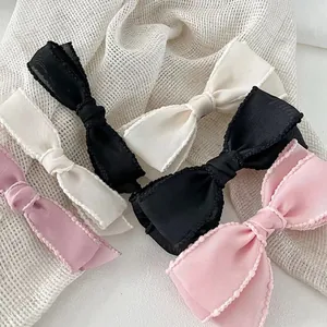 Elegant bow hair clips in black, cream, and pink with polka dot embroidered lace edges