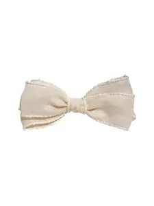 Elegant cream bow hair clip with wavy edges and grosgrain texture on white background