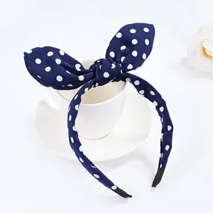 Dettaglio del cerchietto blu navy a pois con orecchie da coniglio su tazza in ceramica