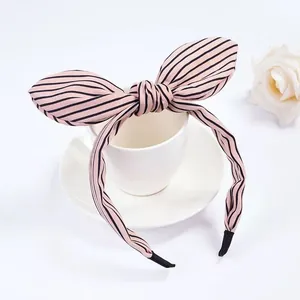 Dettaglio del cerchietto con orecchie di coniglio a righe rosa e nere su tazza