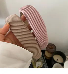 Detail view of thick ribbed headbands in pink and khaki with textured knit fabric