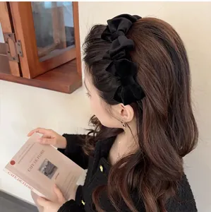 Classic black velvet headband with triple bow design worn by a female model in retro style