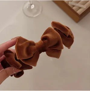 Detail of caramel brown velvet headband featuring layered decorative bow knots