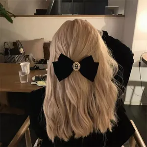 Détail d'un nœud papillon en velours noir français avec centre en perles et roses
