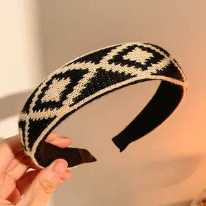 Gros plan d'un bandeau en tricot large avec un motif pied-de-poule classique noir et blanc