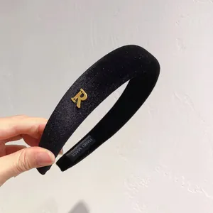 Plush black wide velvet headband with a golden metal letter R logo, handmade style