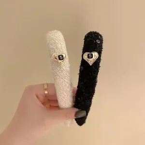 Dettaglio di cerchietti in tweed e paillettes con ciondoli a cuore oro e numero cinque