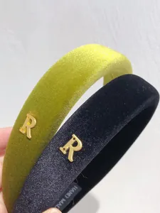 Detailed macro view of velvet hairbands featuring a gold metal letter R and hand made label