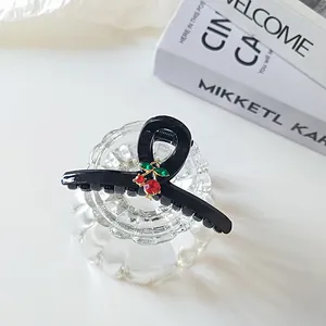 Detailansicht einer glänzend schwarzen Haarklammer mit roten Strass-Kirsch-Akzenten