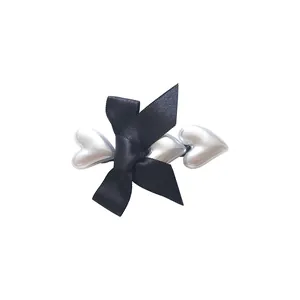 Elegant geometric heart hair clip with black satin bow in silver metallic finish
