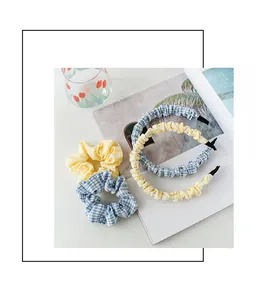Platte lay van gele en blauwe gingham stoffen haarbanden en scrunchies accessoireset