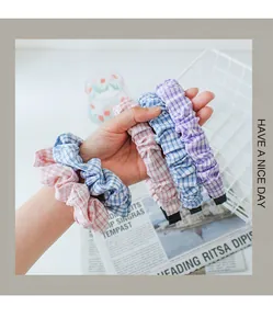 Detailweergave van roze, blauwe en paarse geruite stoffen scrunchies met geplooide textuur