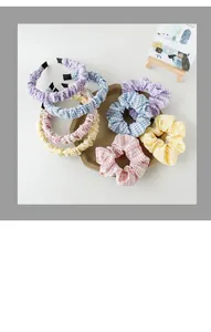Detail van geruite stoffen hoofdbanden en scrunchies in pastelkleuren op een plateau
