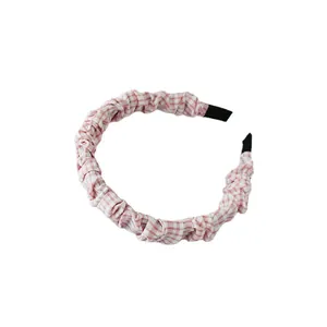Haarband van roze en wit geblokte stof met een modieus geplooid scrunchie-ontwerp