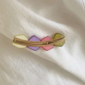 Detail of Korean style colorful geometric crystal resin hair clip on white linen background