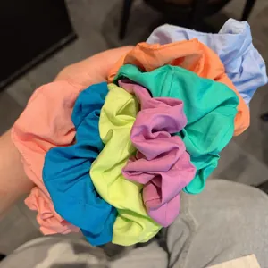 Close-up of colorful pleated fabric scrunchies showing soft texture and elastic design