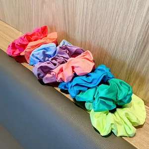 Colorful fabric scrunchies in vibrant hues of pink, orange, blue, purple, and green