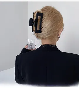 Vue arrière d'une grande pince à cheveux rectangulaire noire mate sur cheveux blonds