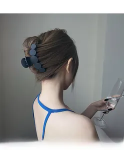 Pince à cheveux noire mate géométrique avec cercles empilés sur une coiffure relevée