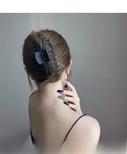 Vue arrière d'une grande pince à cheveux noir mat maintenant un chignon élégant