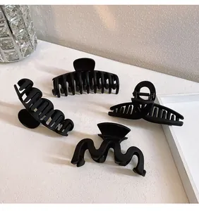 Vue détaillée de quatre pinces à cheveux noir mat aux formes géométriques variées
