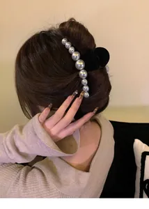 French vintage hair claw clip with elegant pearls on model's dark brown updo hair