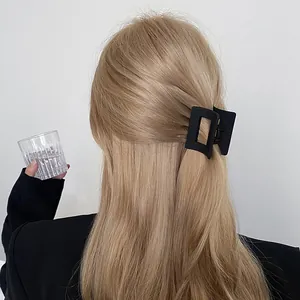 Pince à cheveux rectangulaire noir mat élégante sur cheveux blonds avec une coiffure mi-haute