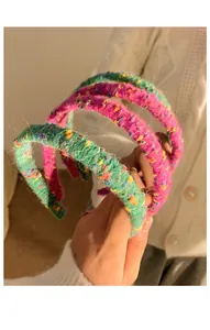 Close-up of vibrant pink and green knitted headbands with soft wool texture