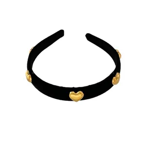 Elegant black velvet headband featuring five polished golden heart-shaped metal accents
