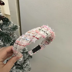 Pink tweed wide headband with fringe and handmade label on holiday background