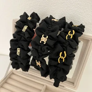Set di tre cerchietti in tessuto nero plissettato con dettagli logo dorati di lusso