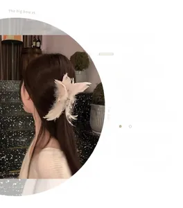 Détail d'une pince à cheveux en plumes d'autruche blanches et strass brillants