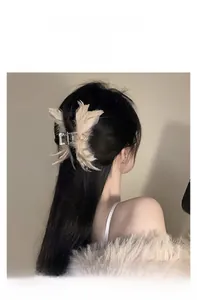Détail d'une pince à cheveux élégante avec plumes d'autruche blanches en forme de papillon